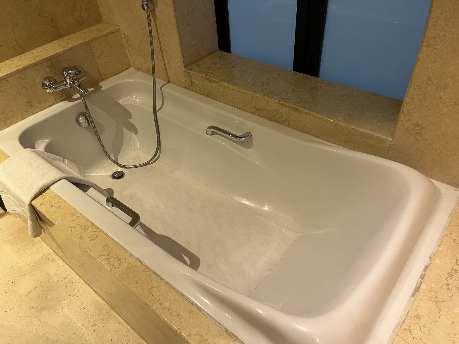 A bathtub at the resort, with a chrome handle on its side